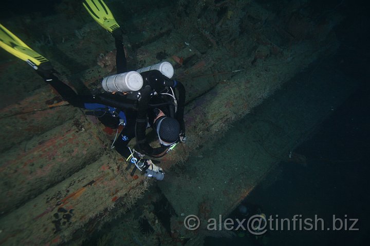 USS_Aaron_Ward-234.JPG - Chris resting on torpedo launcher watches Matt peer inside
